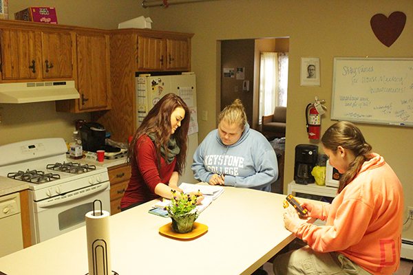 Three Keystone College students study around kitchen counter