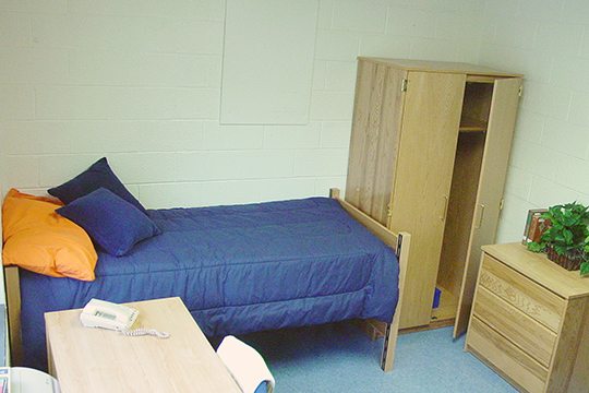 Keystone College dorm room with bed, desk and clothes closet.