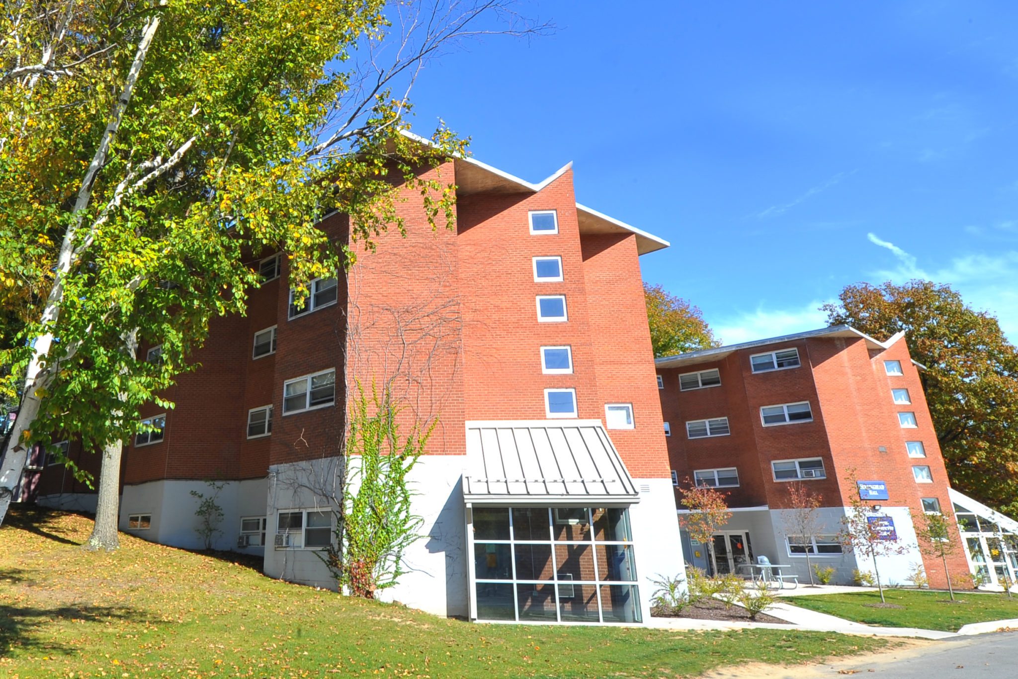 Two brick residence halls with windows and glass entryway at Keystone College
